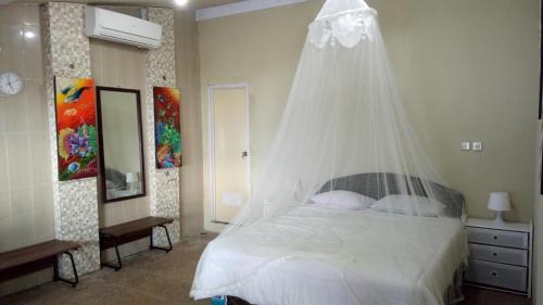 a bedroom with a bed with a mosquito net at Gurara Dive Resort in Tapokreng