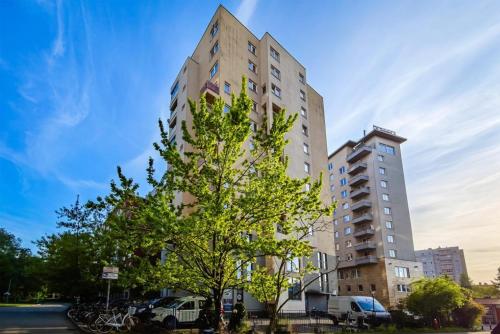 a tall building with a tree in front of it at Hotel Nowa Panorama in Krakow