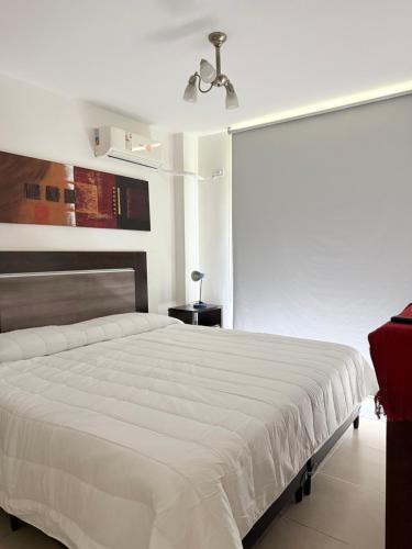 a bedroom with a white bed and a ceiling fan at Cabildo Apart Familiar in Santiago del Estero