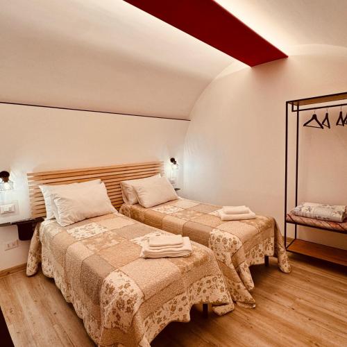 ein Schlafzimmer mit zwei Betten und einem Spiegel in der Unterkunft A Piè Piazza in Barisciano