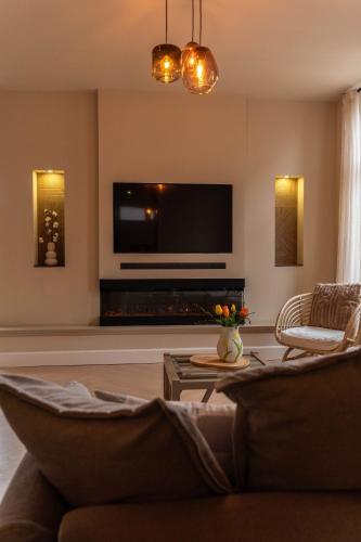 a living room with a flat screen tv on the wall at Tussen poort en toren in Sneek