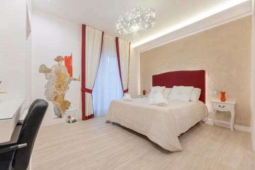 a bedroom with a large bed and a chandelier at Aurum Pompei Suites in Pompei