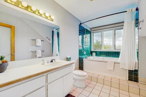 a bathroom with a toilet and a tub and a sink at Loon Landing at Rivergreen in Lincoln