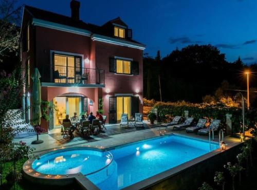 a house with a swimming pool in front of a house at Villa Anita in Gruda