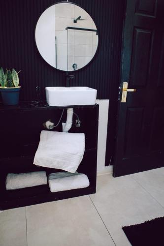 a bathroom with a sink and a mirror and towels at L a Grande deluxe in Benoni