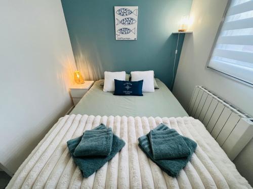 a small bedroom with a bed with towels on it at Au bord de l'eau in Concarneau