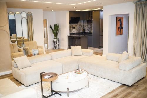 a living room with a white couch and a table at Avenue 28th Apartment in Benin City