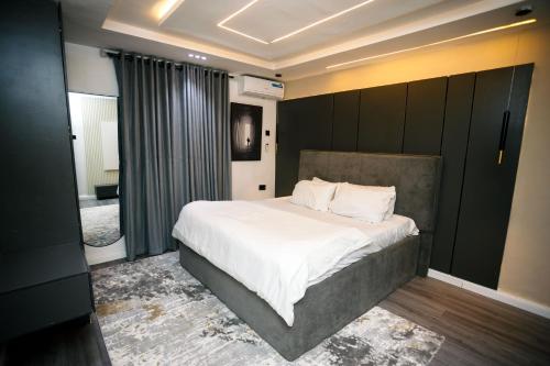 a bedroom with a large bed with white sheets and pillows at Avenue 28th Apartment in Benin City