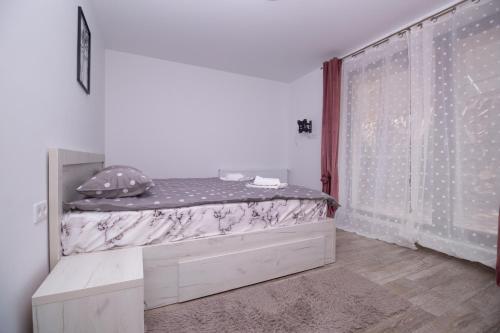 a bedroom with a bed and a window at White Valey Retreat One in Buşteni