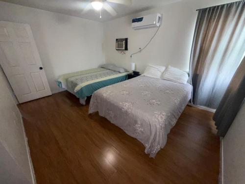 a bedroom with two beds and a window and a door at Flowers Apt 5 Min Walk to Downtown - Free Parking in Las Vegas