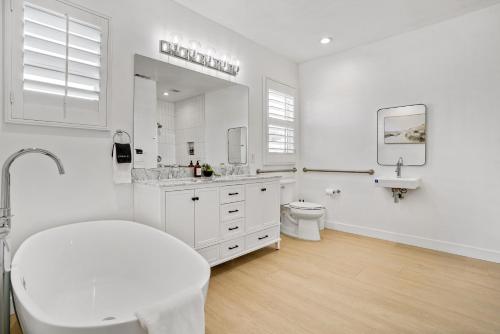 a white bathroom with a toilet and a sink at Indio Access Vacation Home in Indio