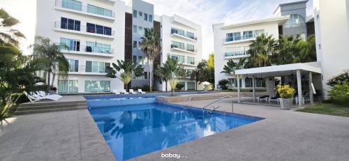 a swimming pool in front of a building at Departamento Isla Marina Mazatlán con alberca in Mazatlán