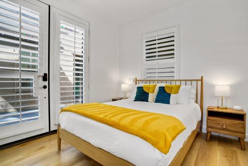 a bedroom with a bed with a yellow blanket on it at Indio Access Vacation Home in Indio