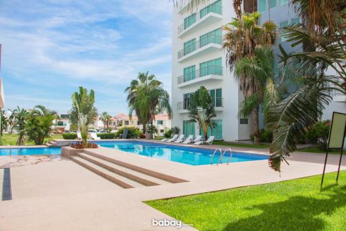 a swimming pool in front of a building at Departamento Isla Marina Mazatlán con alberca in Mazatlán