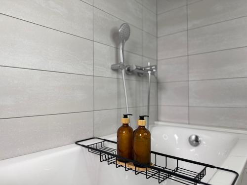 two bottles on a rack next to a bath tub at Bella stan na dan in Široki Brijeg