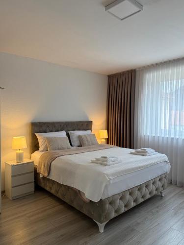 a bedroom with a large bed with two lamps at Bella stan na dan in Široki Brijeg