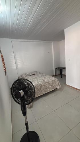 a room with a bed and a fan at Pousada Raios do Sol in Amontada
