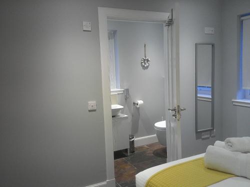 a room with a bathroom with a bed and a toilet at Portree But & Ben in Portree