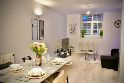 a dining room and living room with a table and chairs at Spacious 4BR Apartment 7 Beds Near Station in Newport