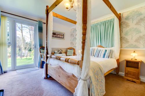 a bedroom with a four poster bed and a window at Meadfoot Guesthouse Room only accommodation for Adults in Windermere