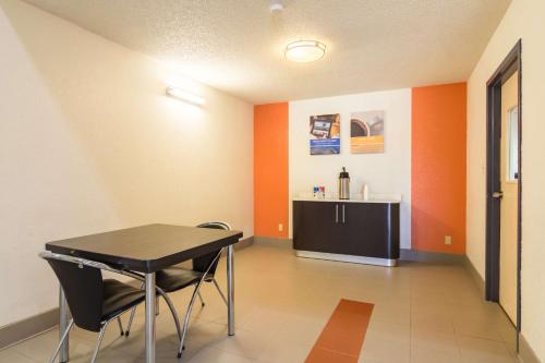 a table and chairs in a room with orange walls at Motel 6-Arkadelphia, AR in Arkadelphia