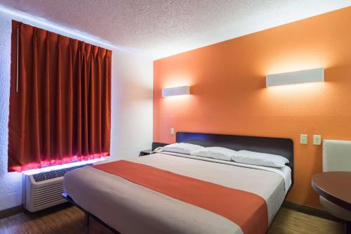 a hotel room with a bed and a red window at Motel 6-Arkadelphia, AR in Arkadelphia