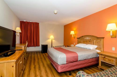 a hotel room with a bed and a flat screen tv at Motel 6-Newark, DE in Newark