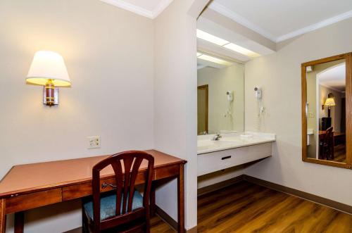 a bathroom with a desk and a sink and a mirror at Motel 6-Newark, DE in Newark