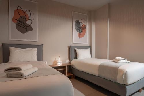 two beds in a hotel room with towels on them at Estia Luxury Apartment in Ierapetra