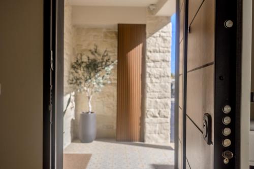 a door to a kitchen with a plant in a vase at Estia Luxury Apartment in Ierapetra