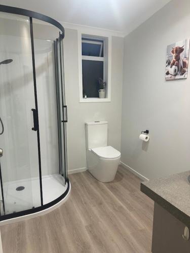 a bathroom with a toilet and a glass shower at Thornton Hideaway Private Standalone Retreat, Walk to Cambridge Town Centre in Cambridge