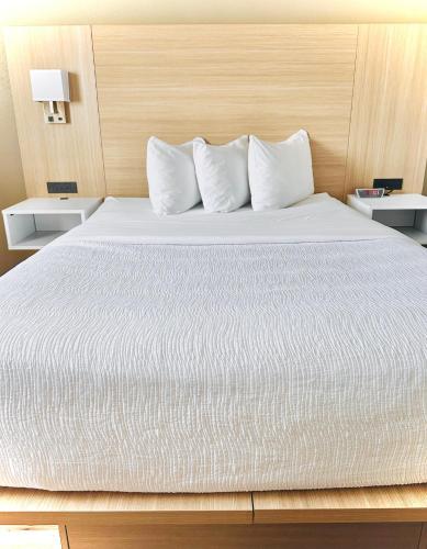 a large bed with white sheets and pillows at Baymont by Wyndham Missoula in Missoula