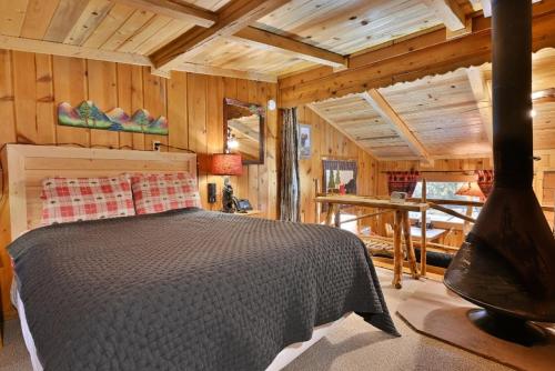 ein Schlafzimmer mit einem Bett in einer Holzhütte in der Unterkunft Pine Haven Resort in Estes Park