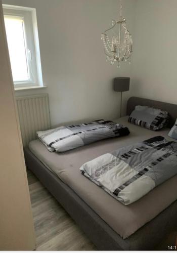 a bedroom with two beds and a chandelier at Wohnung zur Langzeitmiete geeignet in Bad Kreuznach