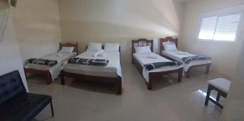 a room with three beds and a couch at Hotel e Restaurante Rota do Pampa in Estância Teixeira