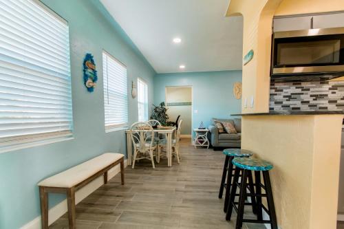 a living room with blue walls and a kitchen with stools at Gorgeous Beach Condo in St. Petersburg