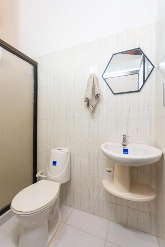 a bathroom with a toilet and a sink at Hotel Casa Encanto in Doradal
