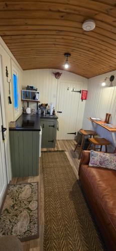 a living room with a couch and a kitchen at North Muasdale Farm - Byre View in Muasdale