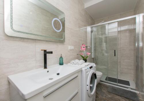 a bathroom with a sink and a washing machine at Apartment Adriatic panorama view in Omiš