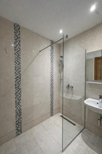 a bathroom with a glass shower and a sink at Libertina Rafailovici in Rafailovici
