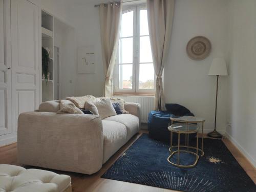 a living room with a white couch and a blue rug at Prestige Loft-Cinéma Privé-King Size-Parking Gratuit-5 min Aéroport Beauvais in Beauvais
