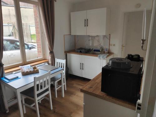 a kitchen with a table and a small kitchen with a table and chairs at Prestige Loft-Cinéma Privé-King Size-Parking Gratuit-5 min Aéroport Beauvais in Beauvais