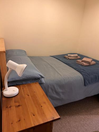a bedroom with a bed and a lamp on a table at Apartment 2 at 2 Bell Street in Talgarth