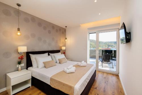 a bedroom with a large bed and a balcony at Villa dal' Mares in Vinišće