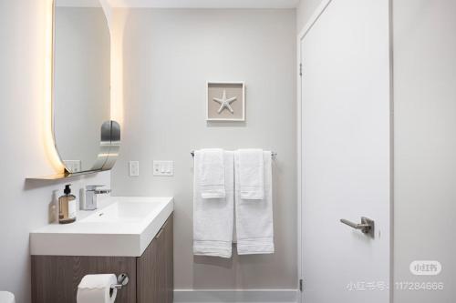 ein Badezimmer mit Waschbecken und Dusche inklusive Handtüchern in der Unterkunft KK Hotel in Markham