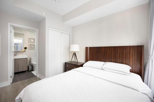 ein weißes Schlafzimmer mit einem großen Bett und einem Badezimmer in der Unterkunft KK Hotel in Markham