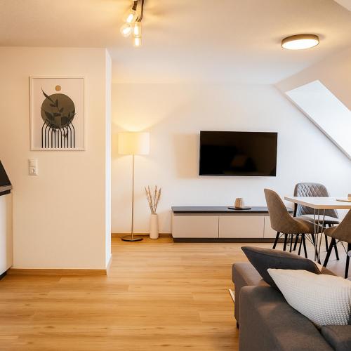 a living room with a couch and a table at Allgäu Suites - Innenstadt, Schlafzimmer, Küche, Parkplatz möglich, Dachterrasse in Kempten
