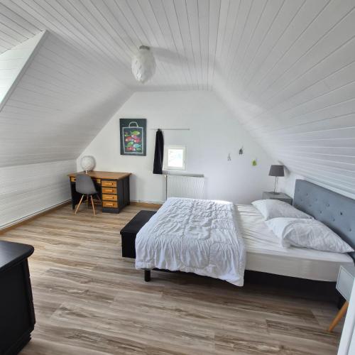 a white bedroom with a bed and a desk at "La Villa du Cap" avec piscine intérieur, billard et à 5 minutes de la plage et des commerces! in Fouesnant
