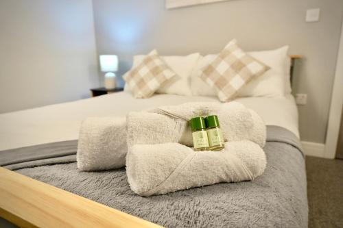 a bed with towels and two candles on it at Spacious 4BR Apartment 7 Beds Near Station in Newport