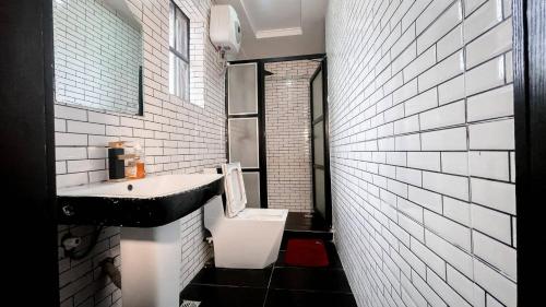 a black and white bathroom with a sink and a toilet at Luxury Hotel Deluxe Room - Sleeps 2 - Gym - Pool in Lekki